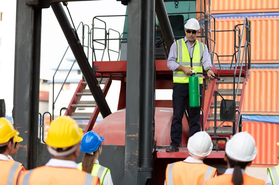 Health and safety training, man giving talk using fire extinguisher