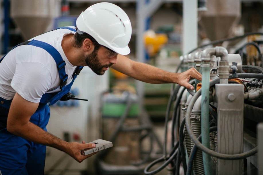 Man in hard hat inspecting machinery