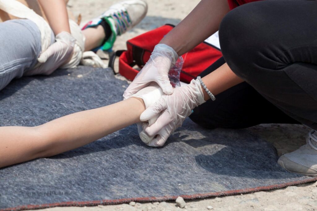 Someone wrapping up a damaged leg on a first aid course