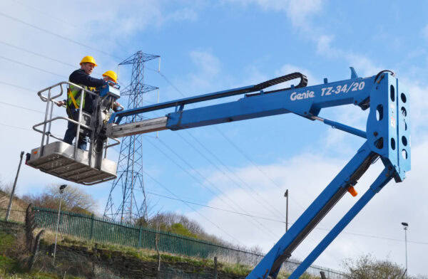 IPAF-certified operator safely maneouvering a cherry picker at height on a construction site, wearing full PPE.